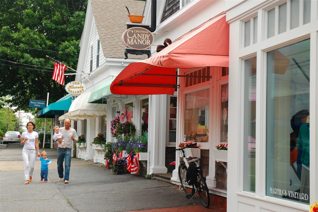 White storefronts with a red awning in Chatham MA