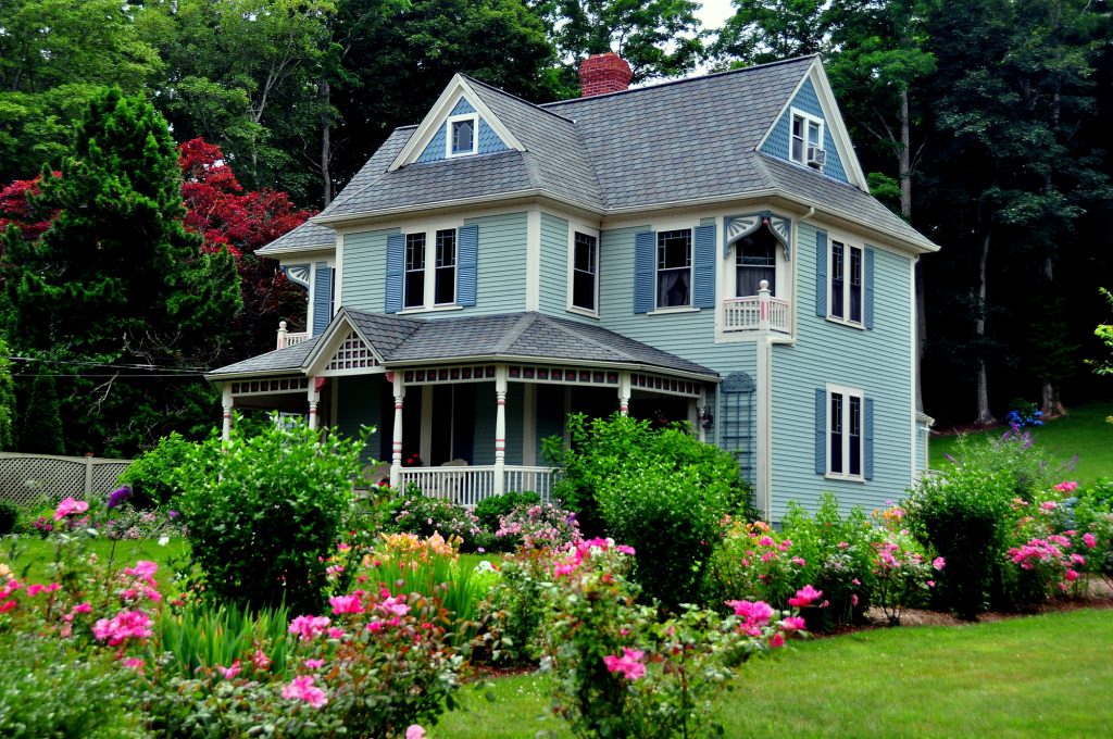 A quaint blue house surrounded by a garden